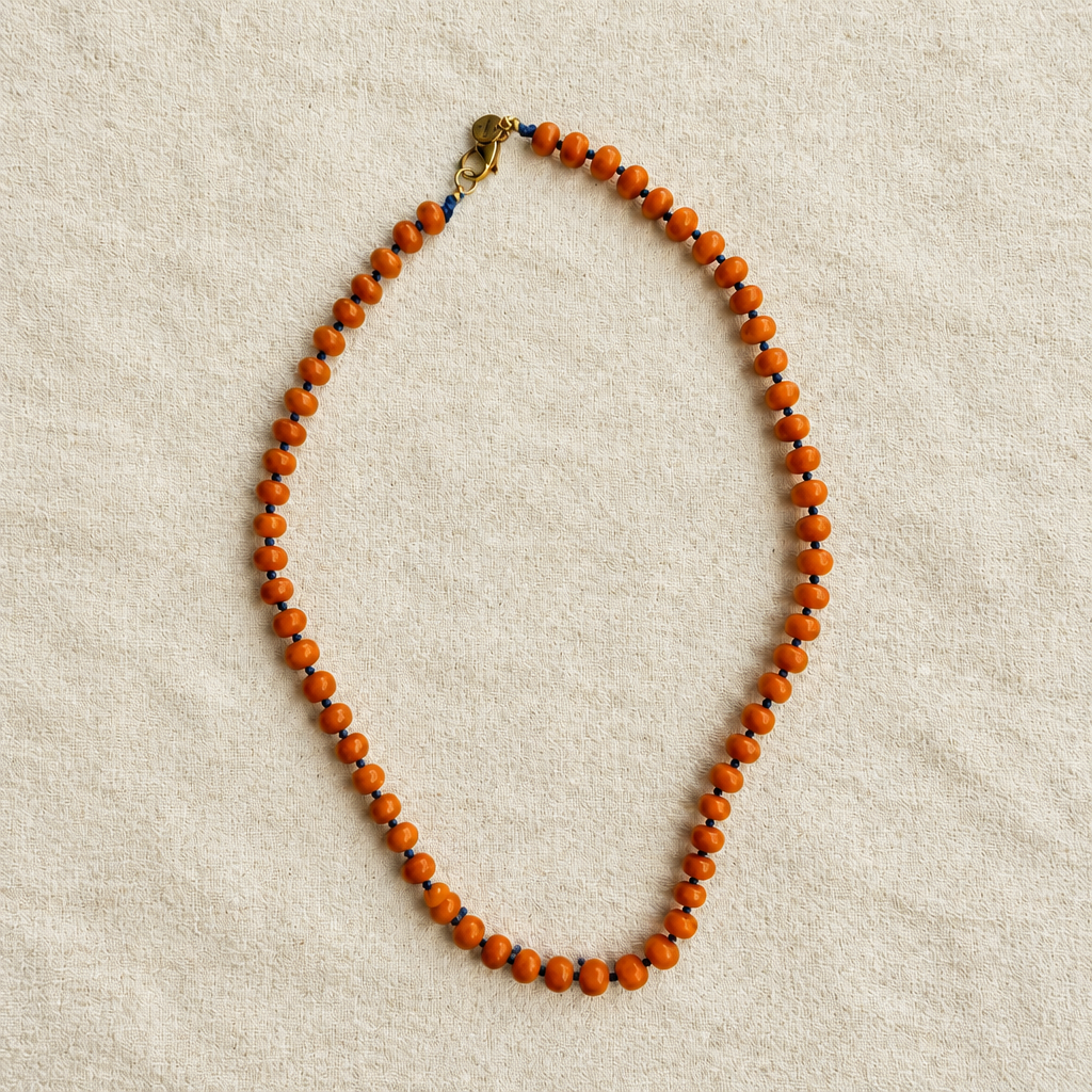 Collar naranja sobre tela rústica crema, foto 3